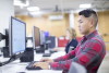 A student working at a computer terminal in think[box]